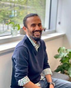 Garvit Bafna smiling by an office window